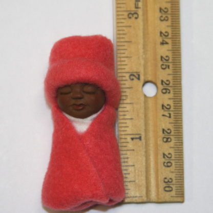 miniature african baby next to ruler