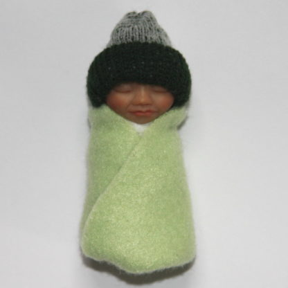 Miniature baby doll in green