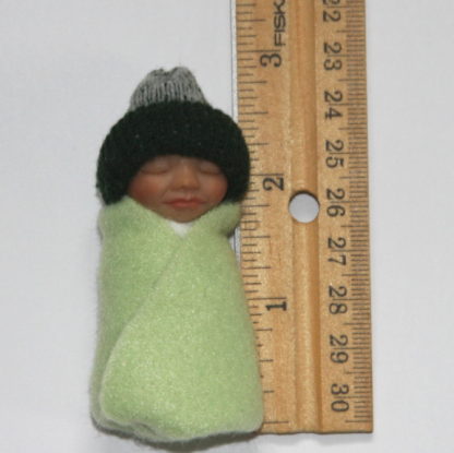 green baby doll bundle next to ruler