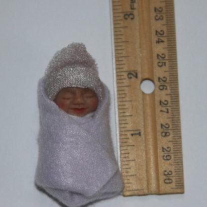 lavender baby doll next to ruler