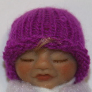 baby girl doll face with knit hat