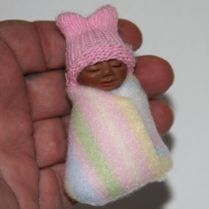 brown skin baby girl doll in hand