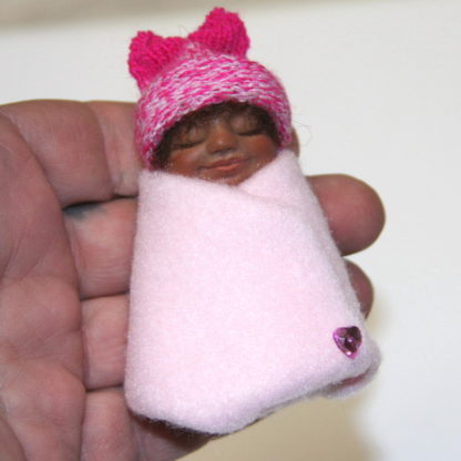 pink Mexican african baby girl doll in hand