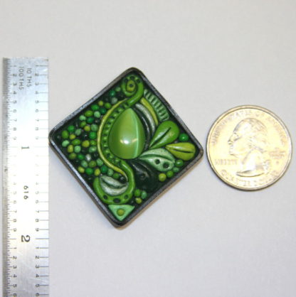 Lime Green Cat Eye Abstract Polymer Clay Cabochon next to ruler