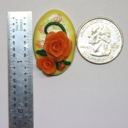 Yellow Cabochon with orange roses next to ruler