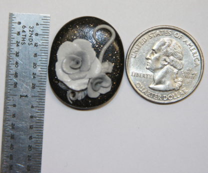 Grey Roses on Black Cabochon next to ruler