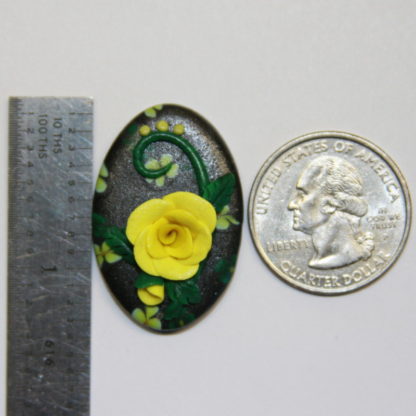 Yellow Rose and Flowers on Black Cabochon next to ruler