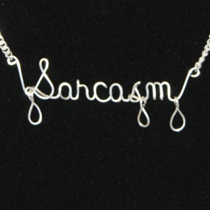 Sarcasm written in Sterling Silver wire with silver drips